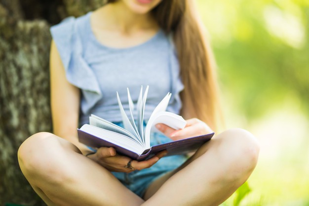 fille faisant de la lecture rapide dans le jardin